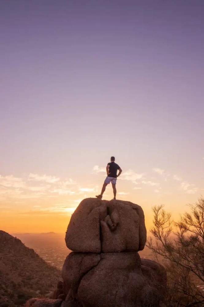 a man with a sunset in the background