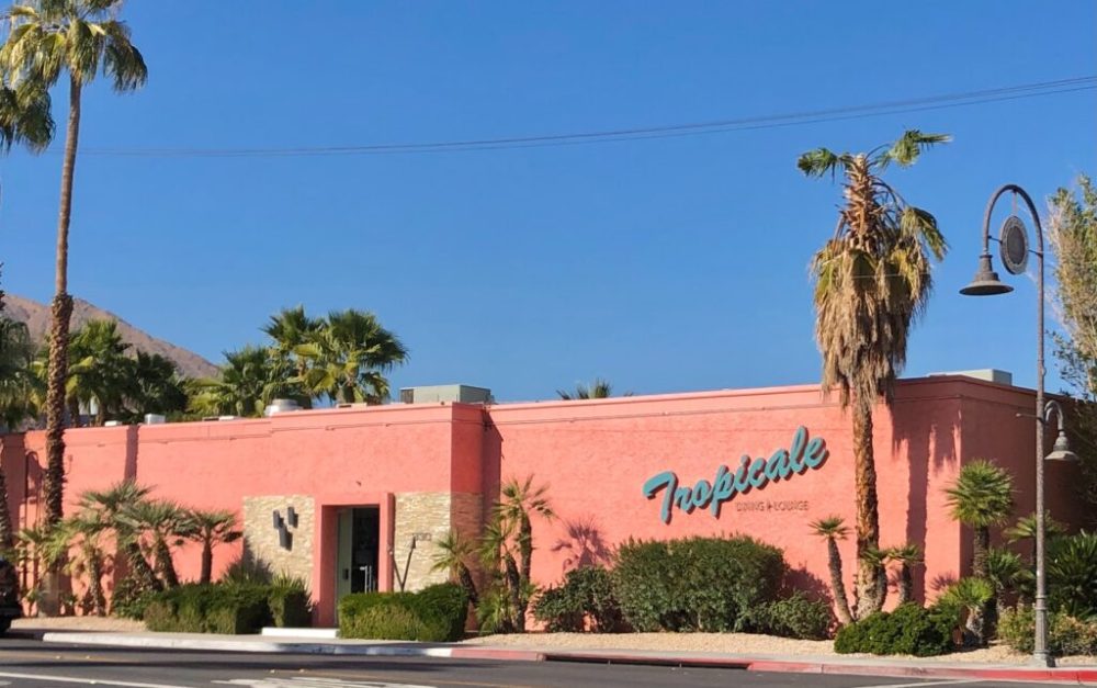 a street lined with palm trees and a building