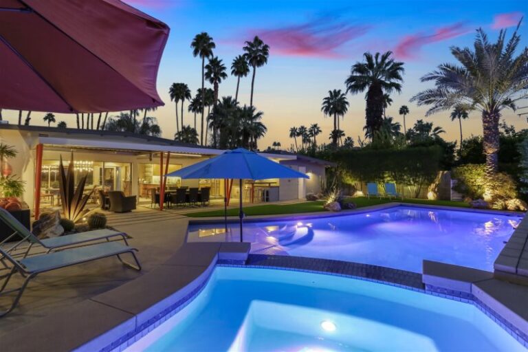 a row of palm trees with a blue umbrella