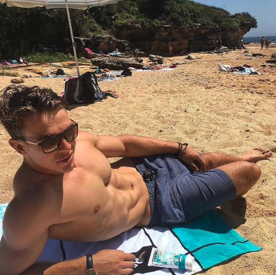 a man sitting on top of a sandy beach