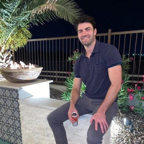 a man standing in front of a fence