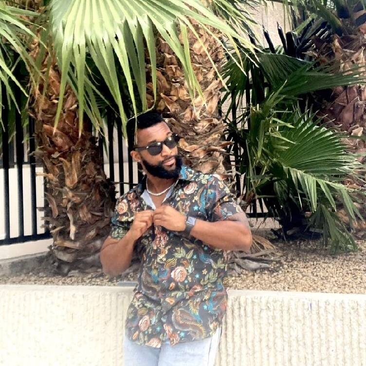 a man standing in front of a palm tree